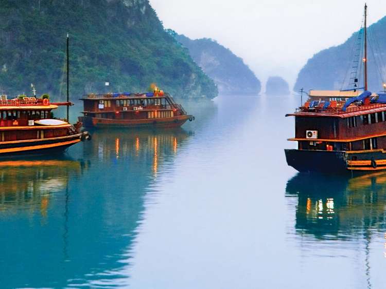 Traditional Vietnam junks float in Halong Bay, one of many sights you can experience on your luxury Seabourn Cruise