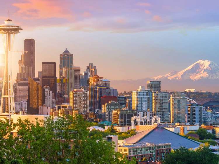 Seattle skyline in sunrise with Mount Rainier in background, a port visited on an all-inclusive, luxury expedition Seabourn cruise.