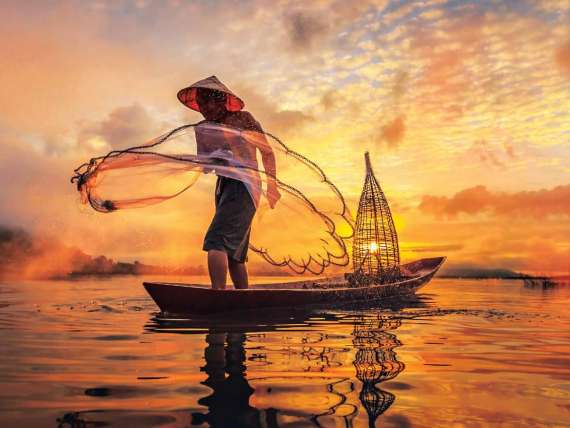 Man fishing on Mekong River, Nong Khai Province, Thailand, a region to visit on an all-inclusive, luxury Seabourn cruise.