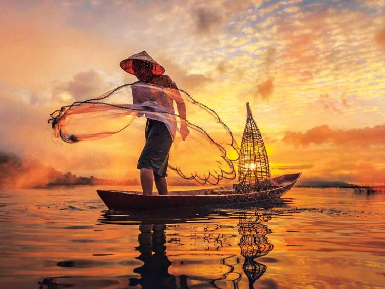 Man fishing on Mekong River, Nong Khai Province, Thailand, a region to visit on an all-inclusive, luxury Seabourn cruise.
