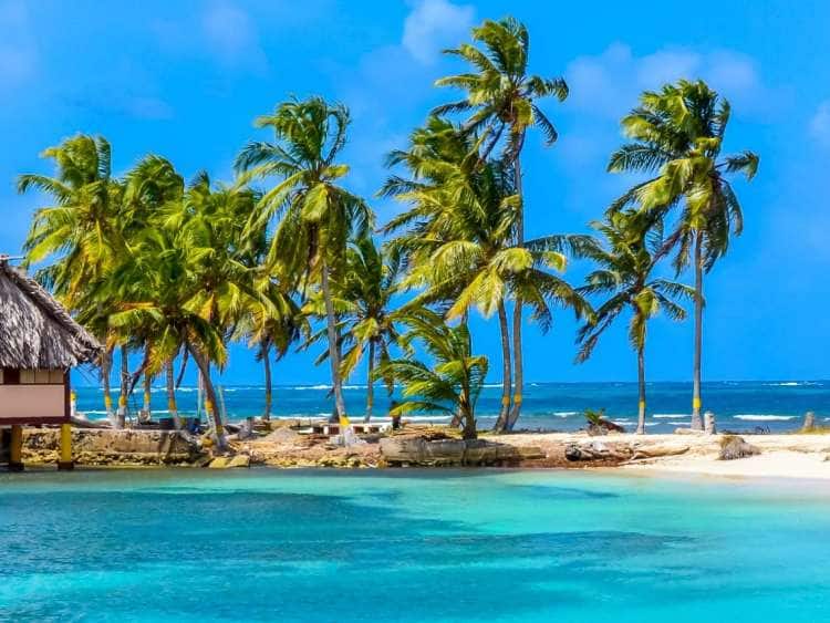 Palm trees and cabanas on a beach in Panama, a destination you can experience on an all-inclusive, luxury Seabourn cruise.