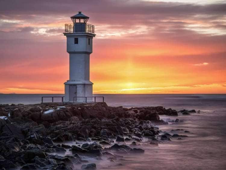 White lighthouse at sunset in Akranes, Iceland, a port visited on an all-inclusive, luxury expedition Seabourn cruise.