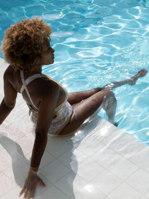 Woman lounging in pool while on an all-inclusive, luxury Seabourn cruise.