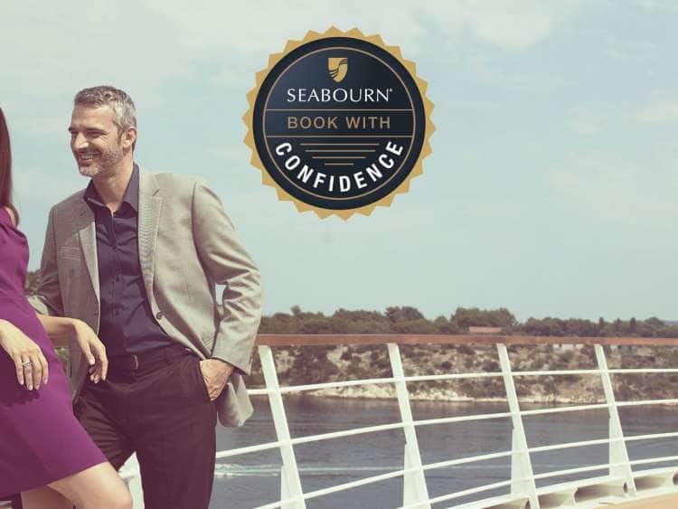 Booking With Confidence logo above a couple relaxing, leaning against the deck railing on board an all-inclusive ultra-luxury Seabourn ship