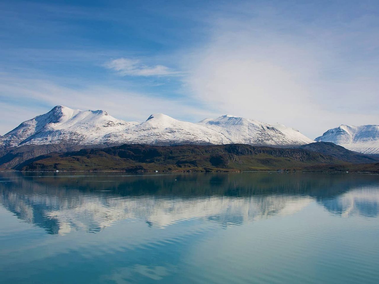 Snowy mountain tops seen from Tunulliarfik Fjord, Greenland, an area visited on an all-inclusive, luxury expedition Seabourn cruise. 