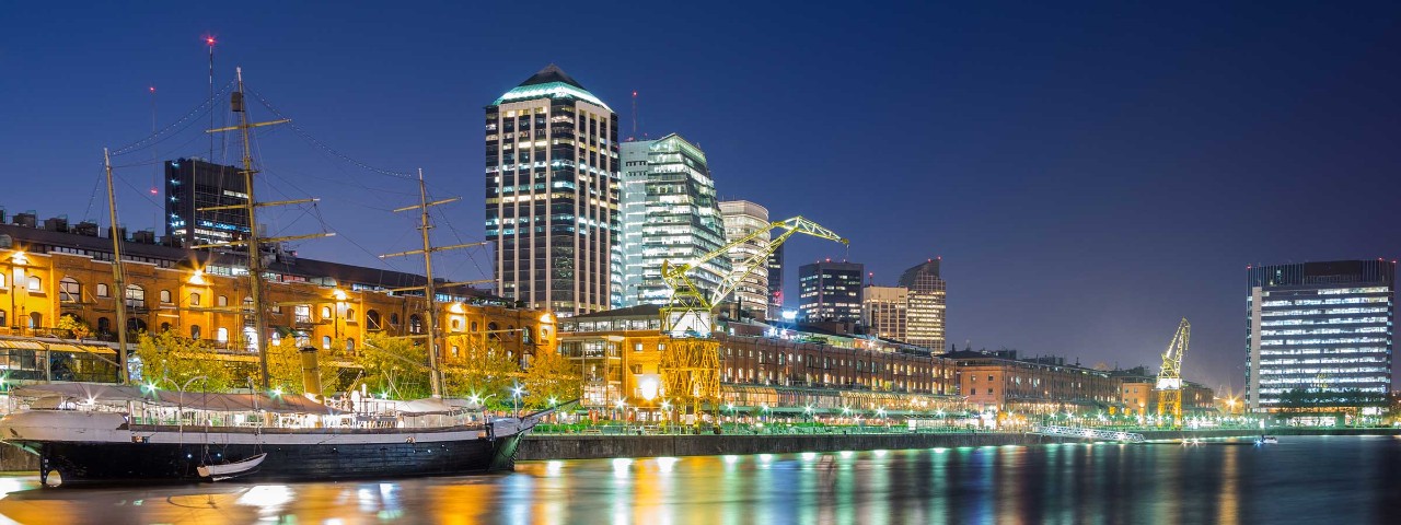 Nighttime city scape of Buenos Aires Argentina with illuminated skyscrapers next to the bay