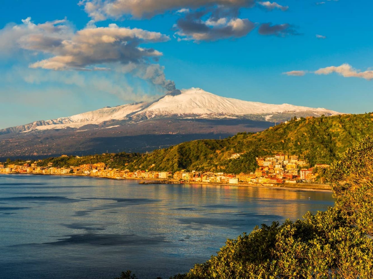  View from Capo Taormina towards Mount Etna and Giardini Naxos, a port visited on an all-inclusive, luxury Seabourn cruise. 