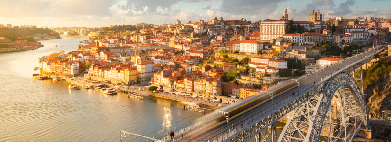Portugal, Oporto, Douro, Porto at sunset with a train on Louis I bridge over Douro River