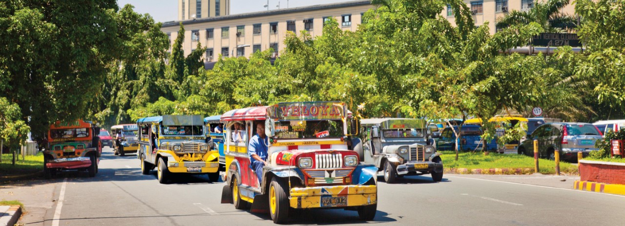 E783HH Jeepney a popular public transportation in Manila, main city in the Philippines. Background of the streets is the City hall.