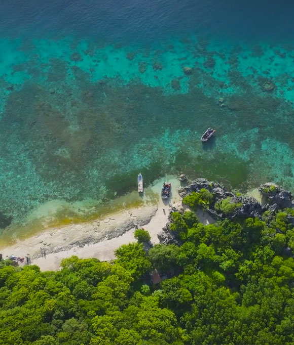 A group of Seabourn Expedition zodiacs float near the pristine shoreline of Yasawa Island, Fiji.