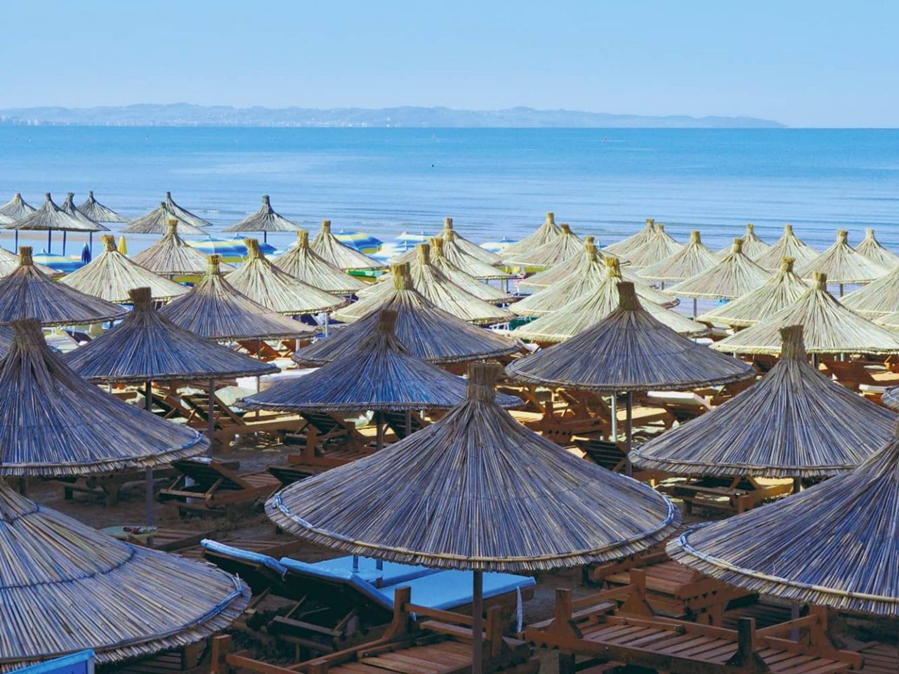 Beach umbrellas near the shoreline in the resort area of Durres, Albania, a port visited on an all-inclusive, luxury Seabourn cruise. 