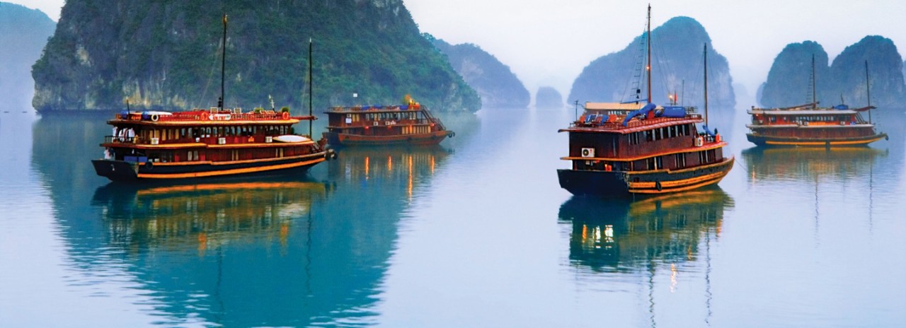 Traditional Vietnam junks float in Halong Bay, one of many sights you can experience on your luxury Seabourn Cruise