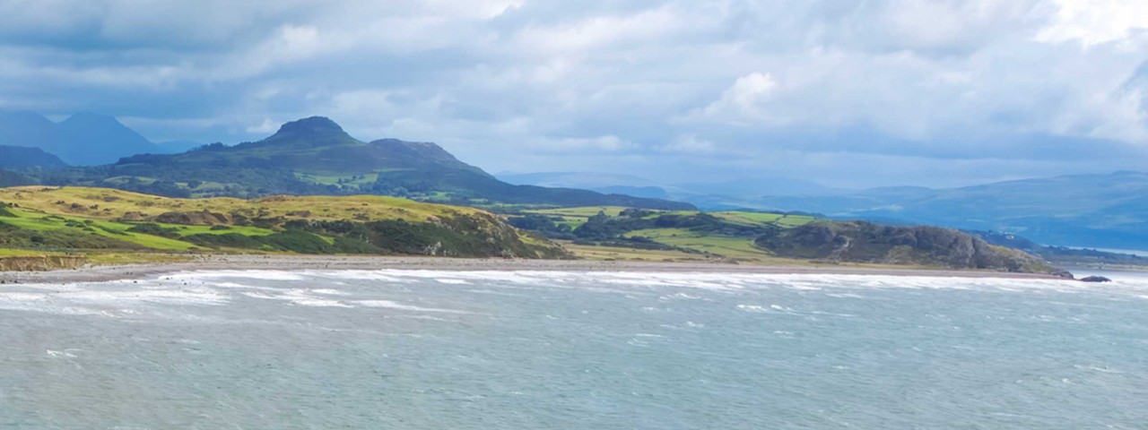 ocean with mountain silhouette in background in Wales