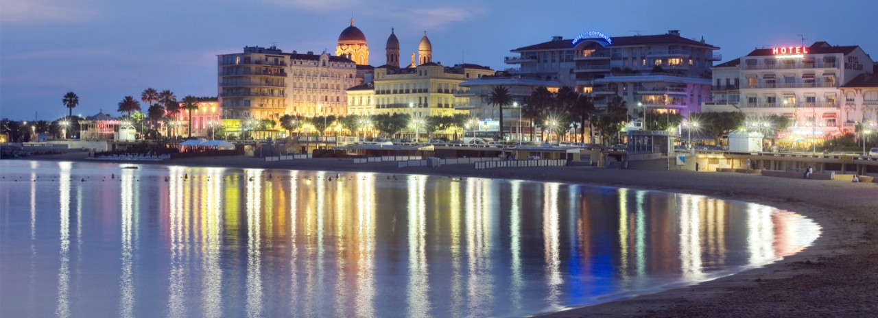 France, Provence-Alpes-Cote d'Azur, Frejus, View of St Raphael with the Notre Dame de la Victoire de Lepante church reflecting in the sea at dusk