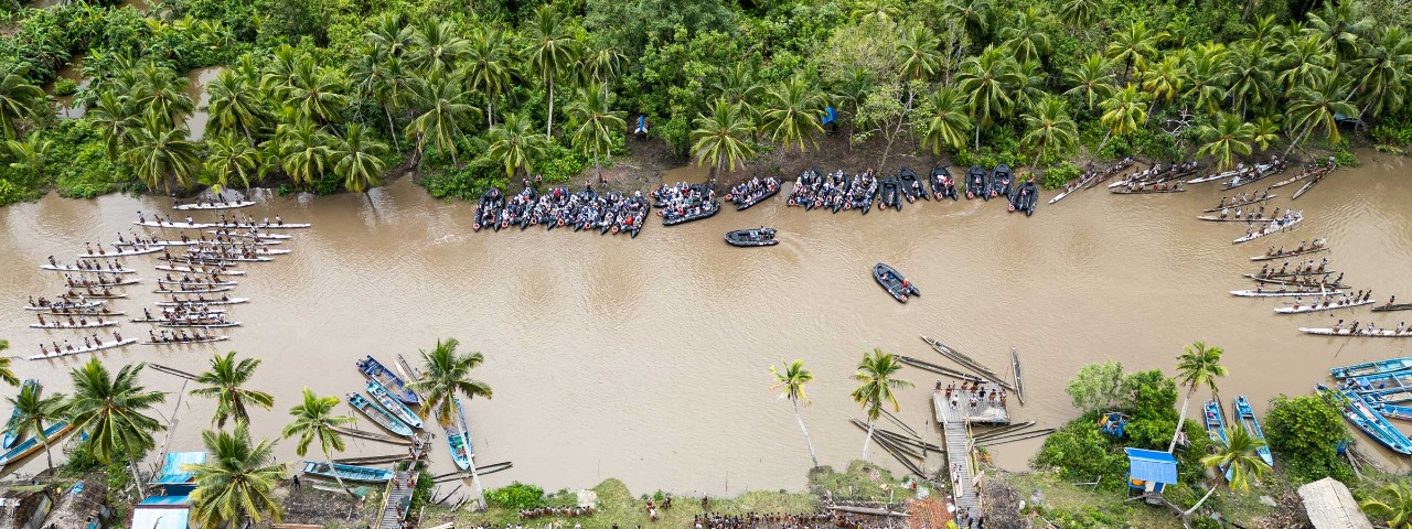 River Boats and zodiacs on river surrounded by trees in Per, Indonesia